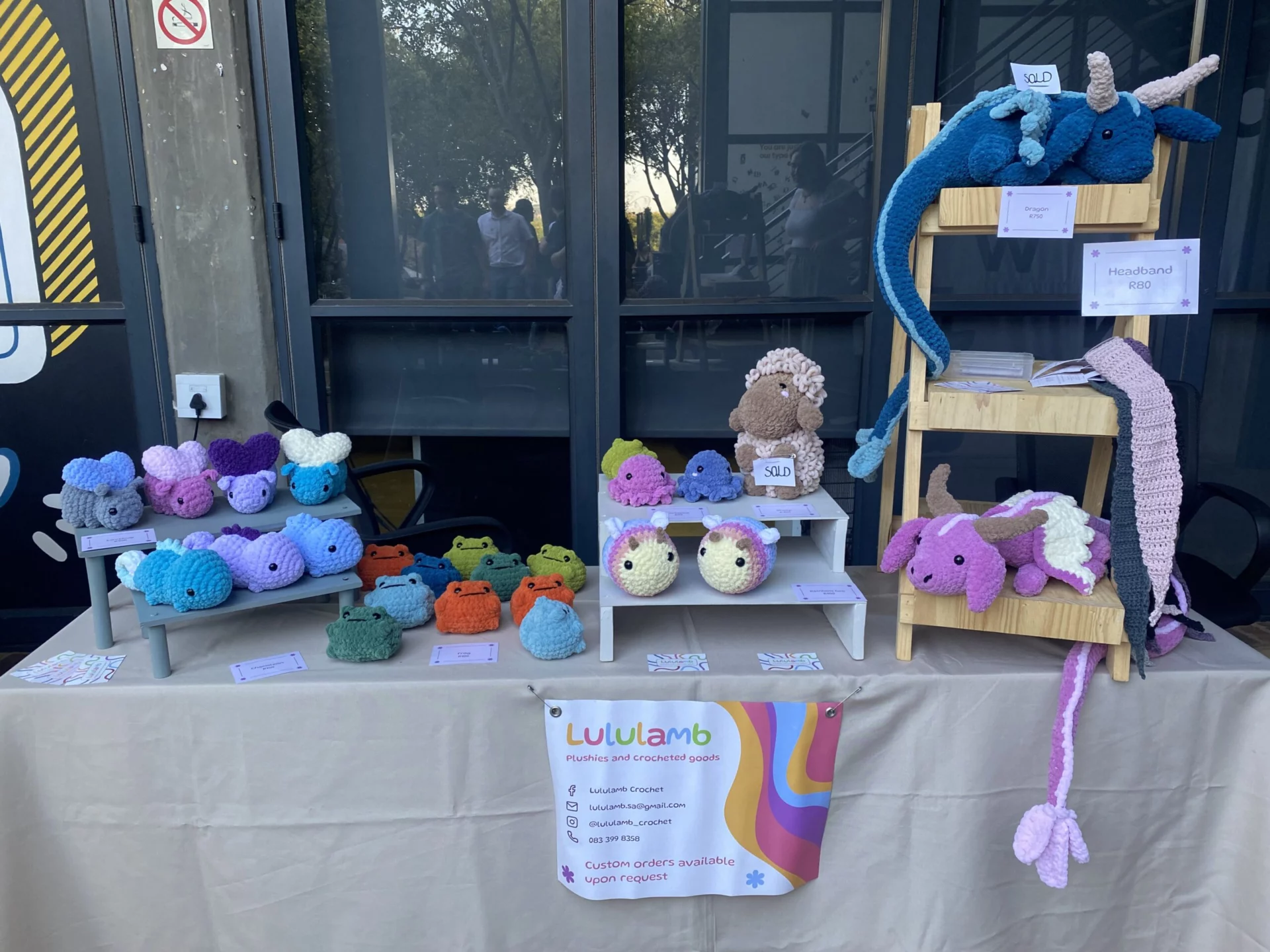 A table filled with various colourful crocheted plushies of a variety of animals
